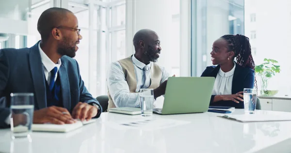 An employment lawyer reviewing documents with a client across a desk in a bright office