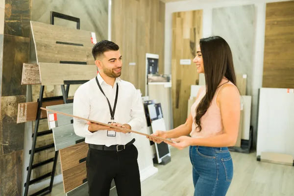 A flooring company owner reviewing marketing results on a laptop in a hardwood and tile showroom