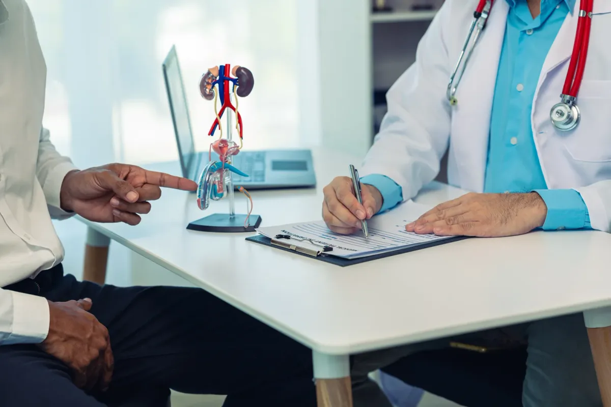 Nephrologist reviewing a kidney function lab report with a patient in a clinic exam room