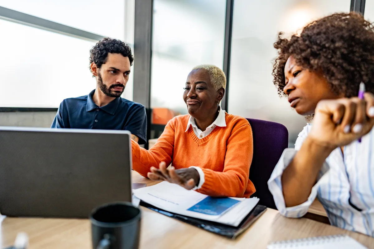 A nonprofit fundraising team reviewing donor and campaign data together on a laptop in an office