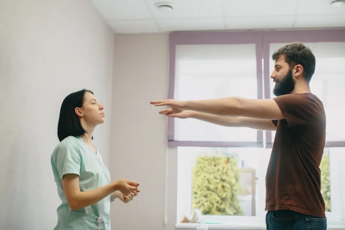 A pelvic floor physical therapist reviewing an exercise plan with a patient in a private treatment room