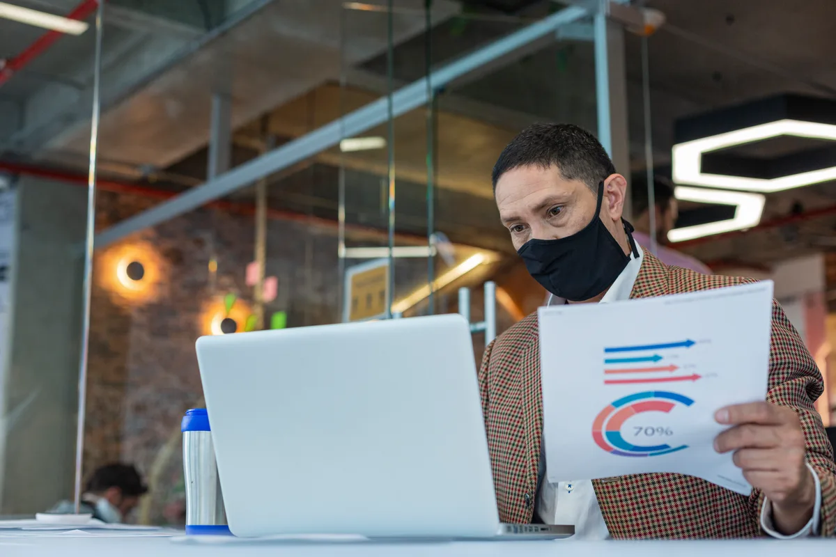 Pest control company owner reviewing lead and booking reports on a laptop at a desk