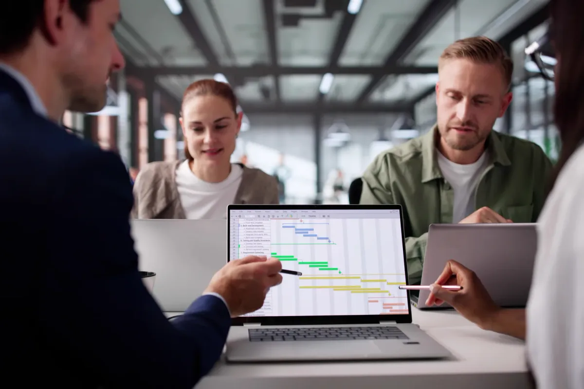 Property manager reviewing a rent-roll dashboard on a laptop in a leasing office