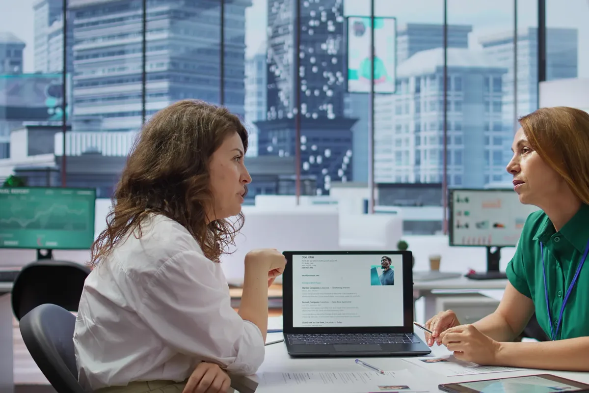 An HR manager reviewing candidate profiles in an applicant tracking system on a desktop monitor