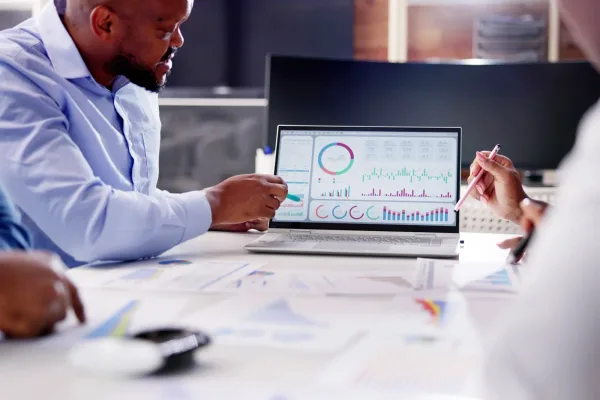 A data engineer reviewing a data pipeline dashboard with warehouse and CRM connections on a monitor