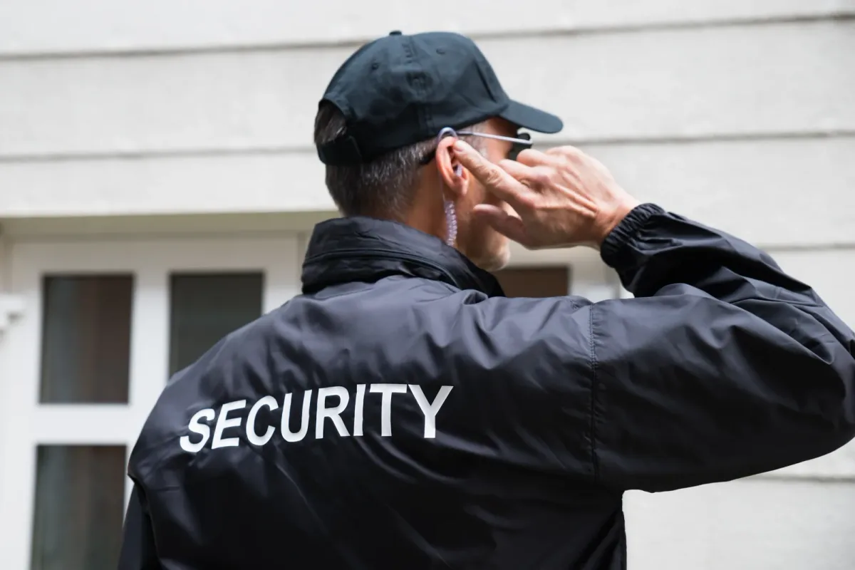 Uniformed security guard patrolling the exterior of a commercial building