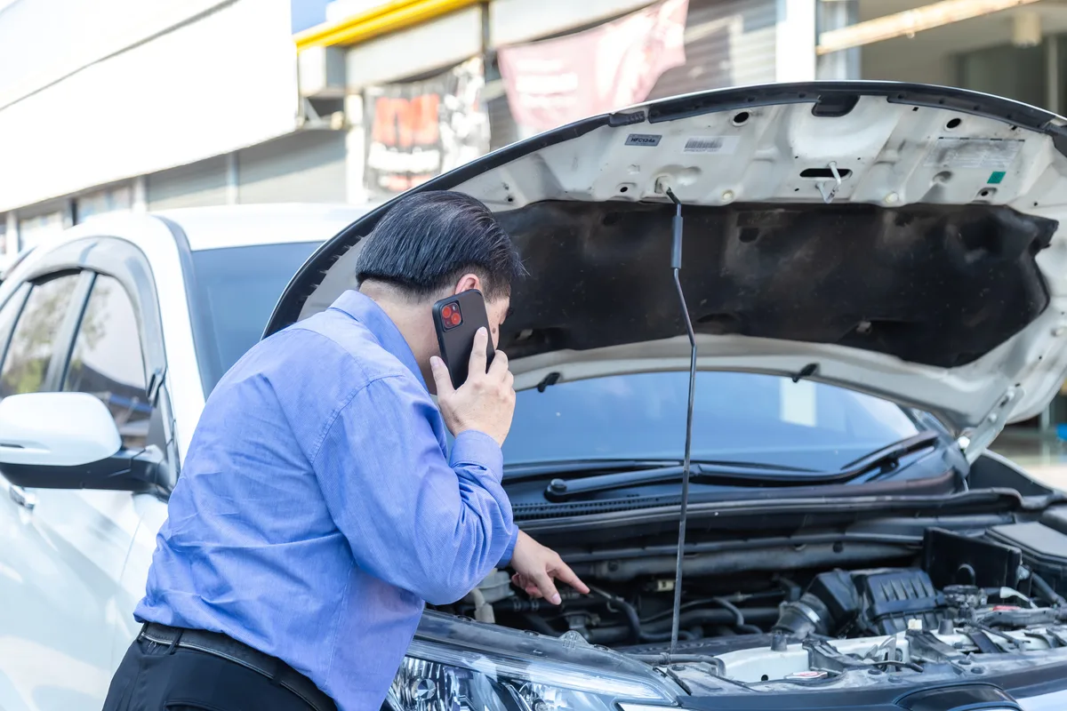 Tire shop owner meeting with a marketing advisor inside the service bay area of an auto shop
