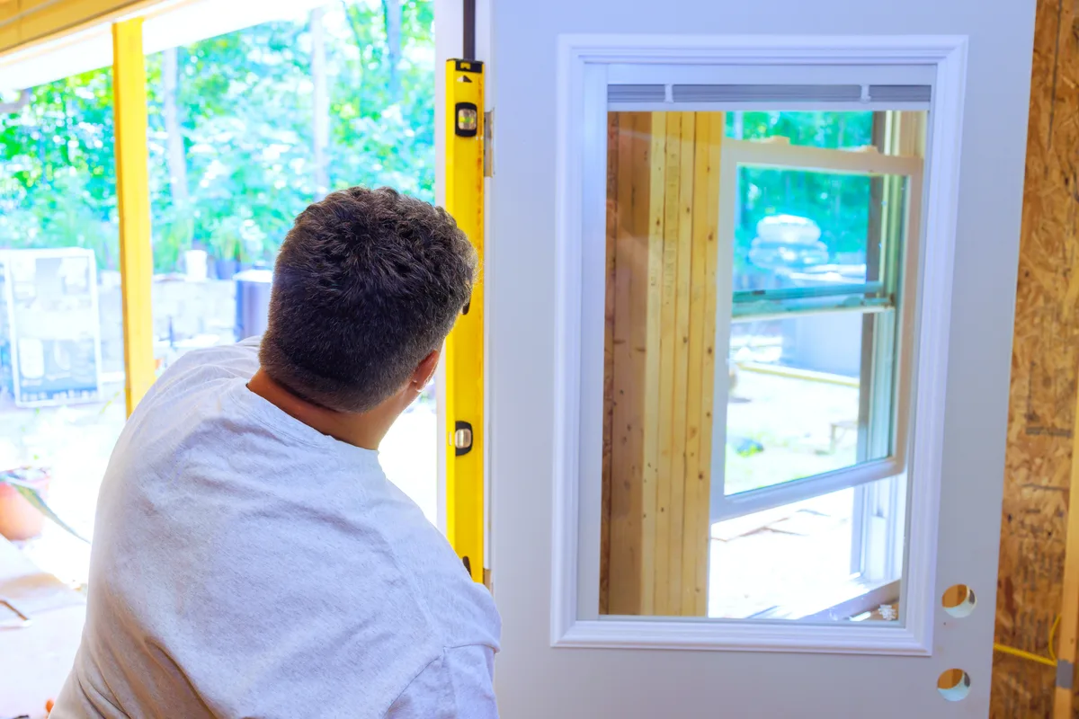 Installer fitting a new energy-efficient replacement window in a home