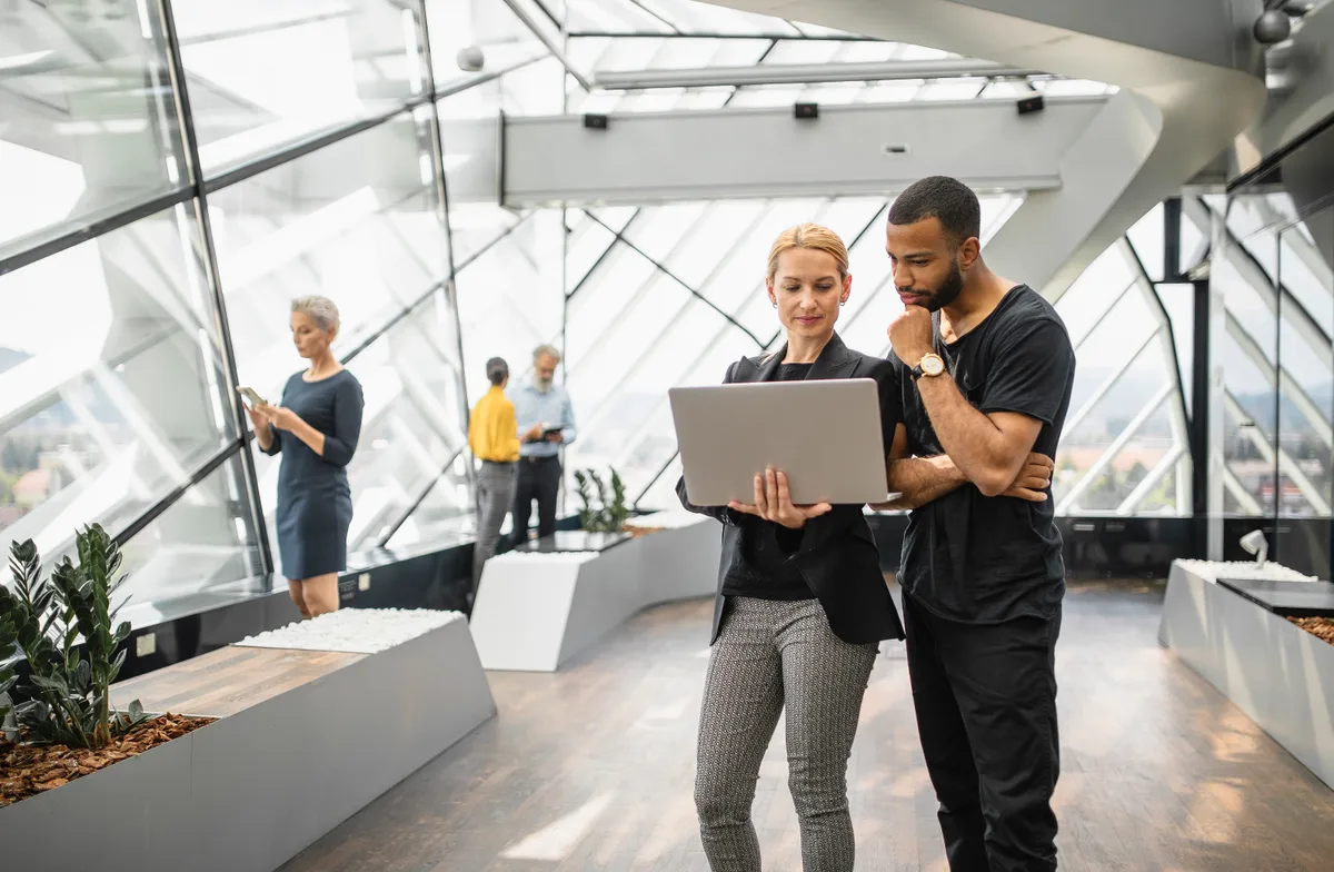 Yoga studio owner reviewing marketing performance on a laptop at the studio's front desk