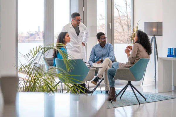A board-certified plastic surgeon reviewing options with a prospective patient during a consultation in a bright modern clinic