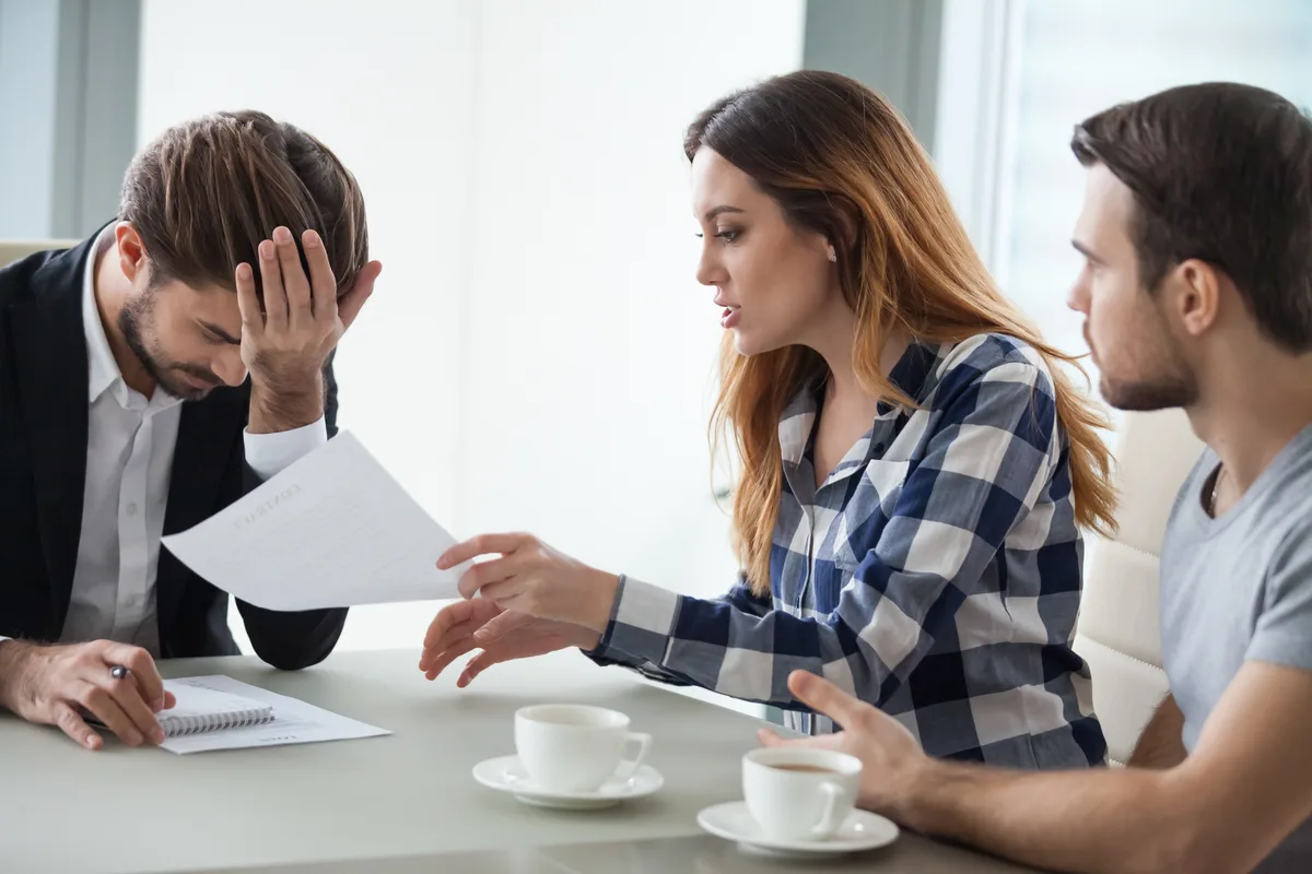 A debt relief specialist reviewing repayment options across a desk with a concerned couple