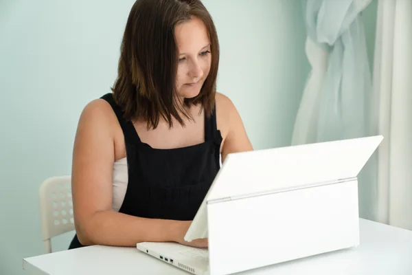 An event planner reviewing client inquiries and bookings on a laptop in a bright studio
