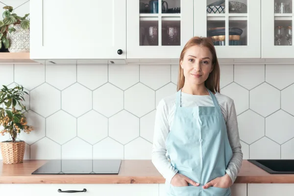 Professional house cleaner wiping down a kitchen counter in a bright, modern home