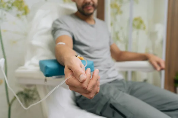 A patient seated comfortably while receiving an IV vitamin drip in a bright, modern wellness clinic