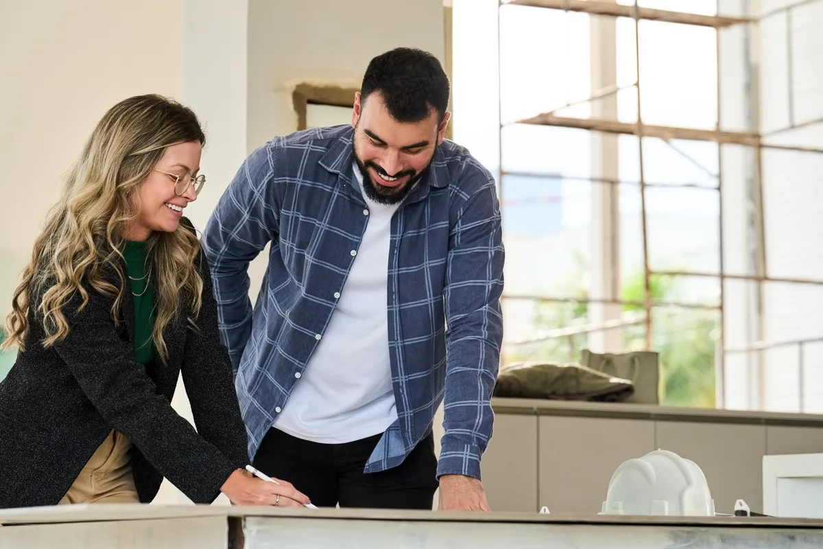 A kitchen and bath remodeler reviewing design plans with homeowners at a showroom counter