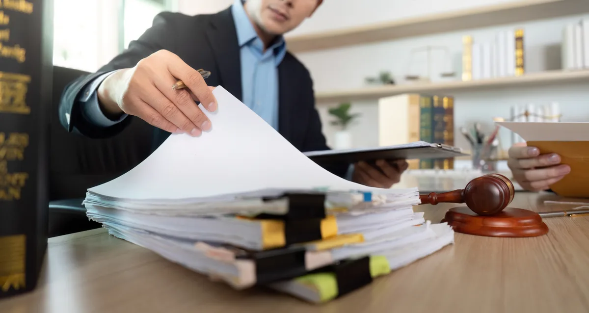A medical malpractice attorney reviewing hospital records and case files at a desk