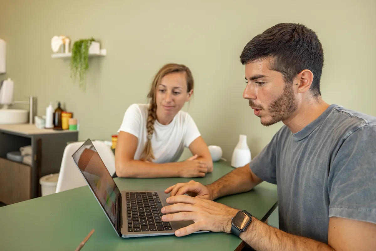 Physical therapy clinic front desk with a laptop showing an online scheduling calendar