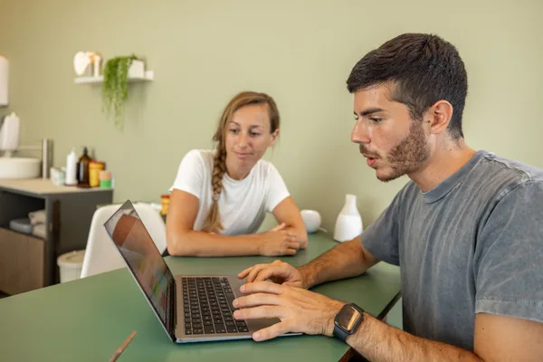 Physical therapy clinic front desk with a laptop showing an online scheduling calendar