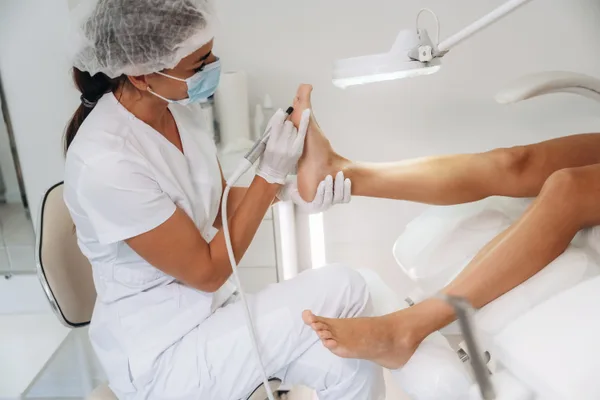 A podiatrist examining a patient's foot during an appointment in a clinic exam room
