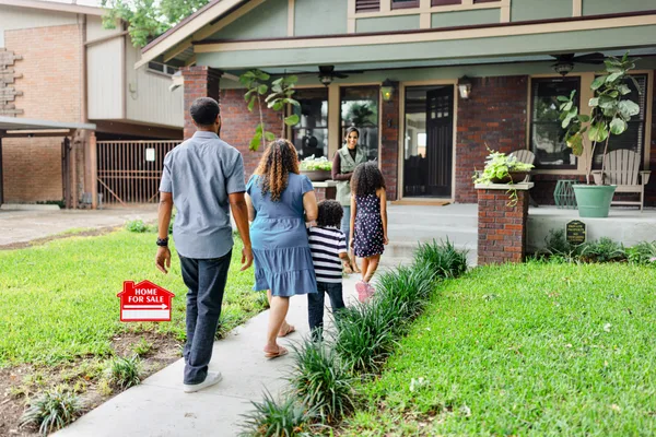 A real estate agent reviewing listing details with a couple inside a bright, modern home