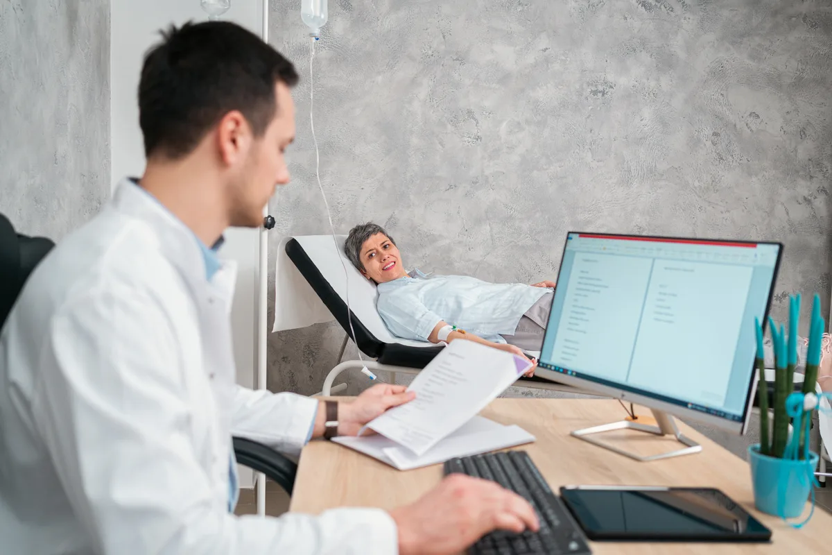 Sleep medicine specialist reviewing a patient's overnight sleep study data on a clinic monitor