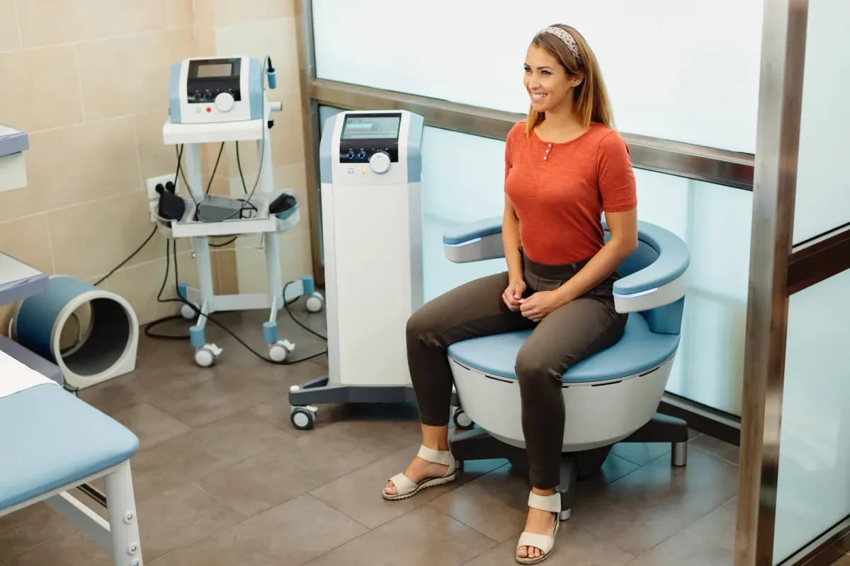 Patient seated in a treatment chair with a TMS coil positioned near the head in a calm clinic room