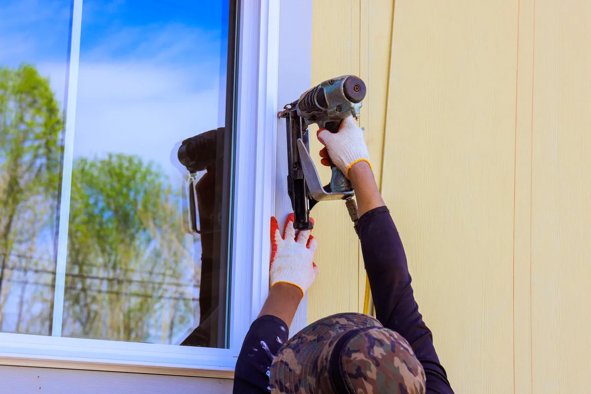 Installer fitting a new energy-efficient replacement window into a residential home