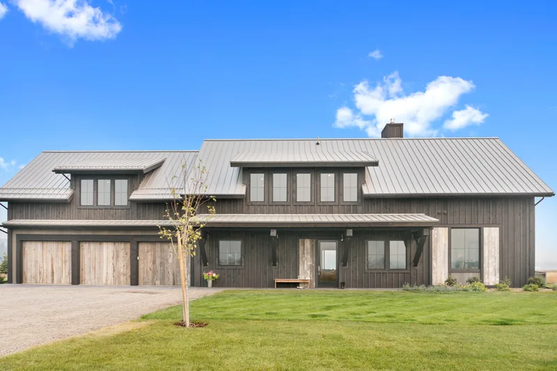 Dark board-and-batten cedar and standing-seam roof of Hollis Farmhouse in the Carrington valley