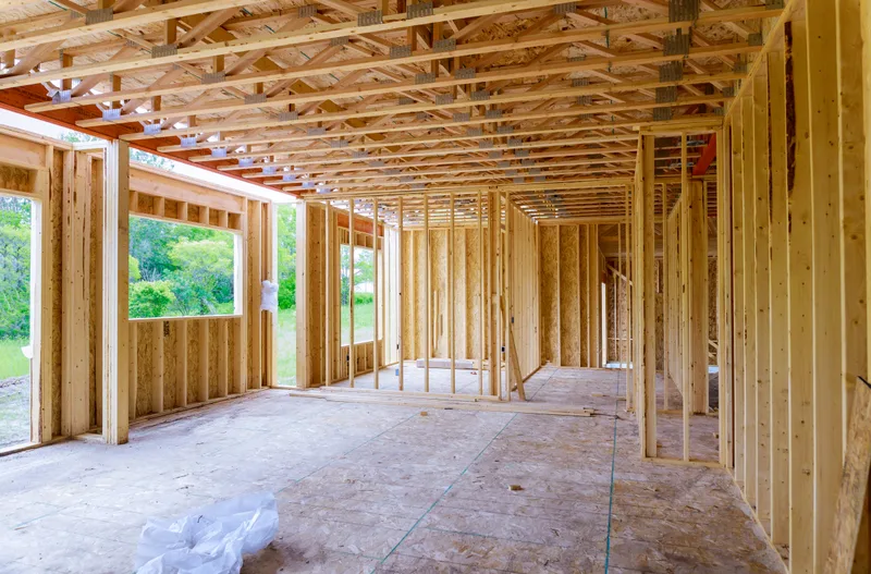 Open stud walls and roof framing inside a home addition before insulation