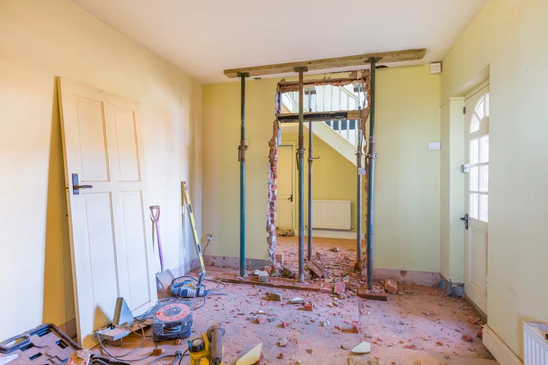 Temporary steel posts holding up a wall opening while a load-bearing wall is removed