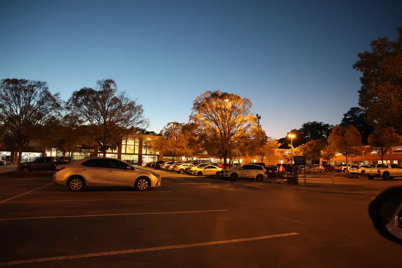 Retail parking lot under evening lights with fresh pavement markings