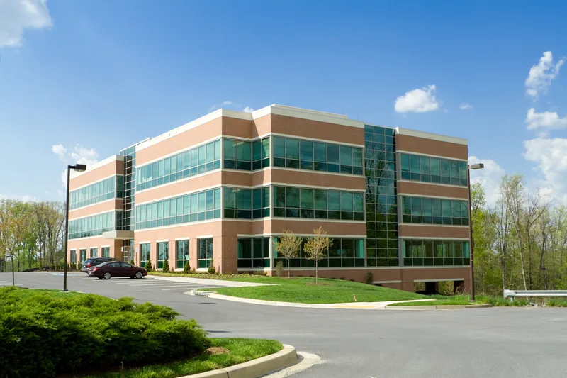 Three-storey office building with a paved and curbed parking lot