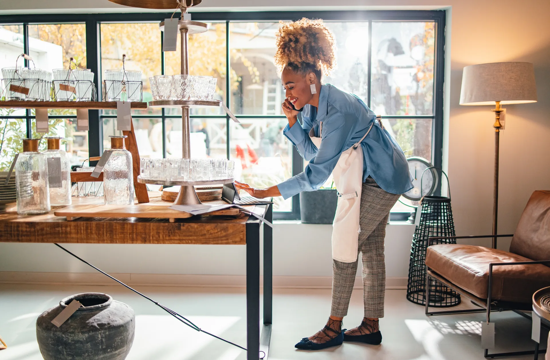 A store owner taking a customer call in her shop — the kind of business this process is built around