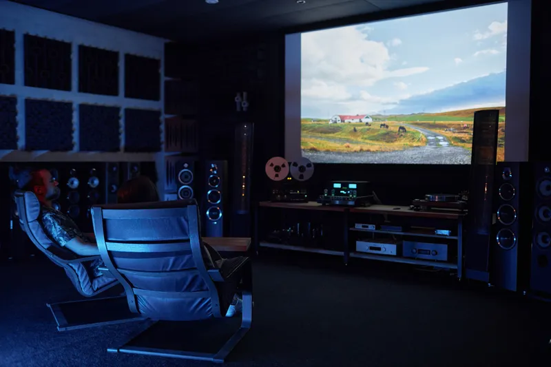 The Drift Audio listening room: tower speakers, a reel-to-reel deck, and two listening chairs in low light