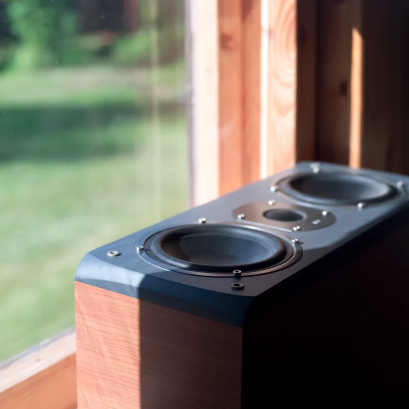 A wooden hi-fi speaker cabinet catching afternoon sun on a windowsill