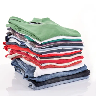 Tall stack of freshly folded tees, polos, and jeans in greens, whites, reds, and blues