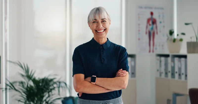 Dr. Ingrid Lindqvist, with short silver hair, smiling with arms crossed in the clinic