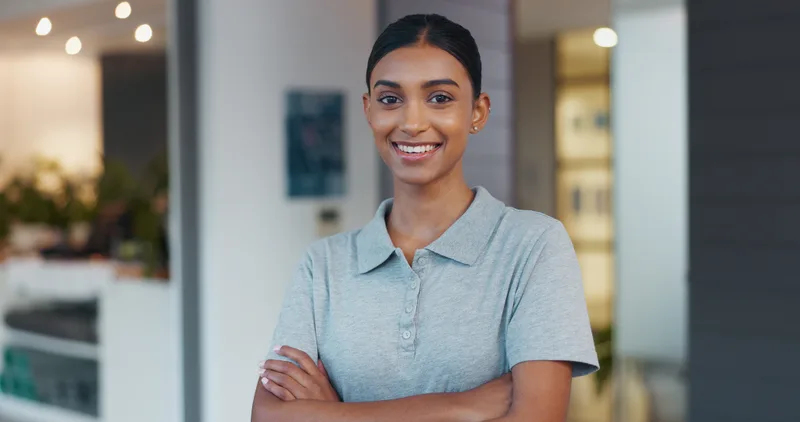 Dr. Anjali Rao smiling in a light blue clinic polo with her arms crossed