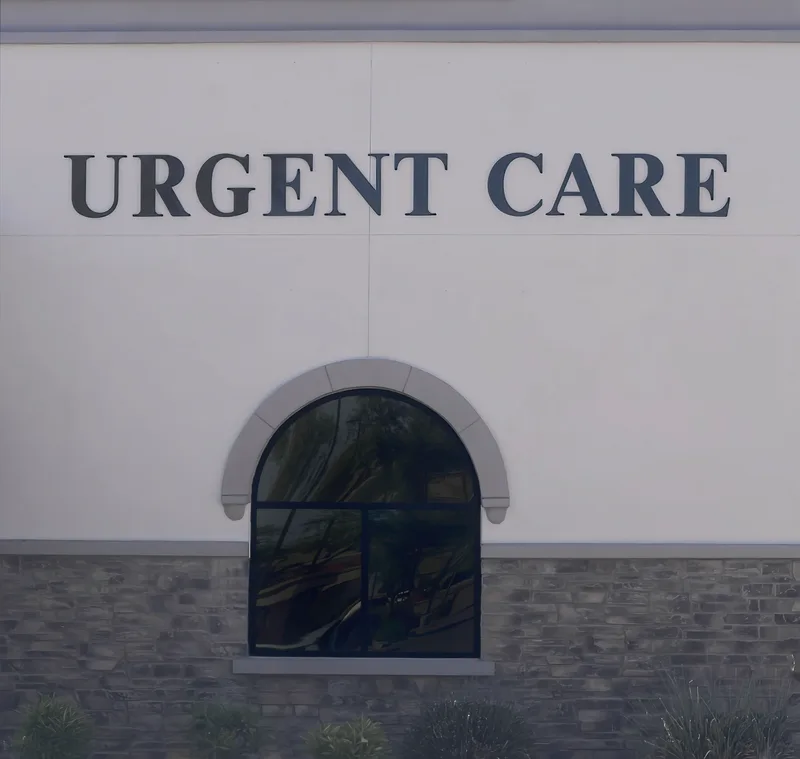 Clinic exterior with large 'Urgent Care' lettering above an arched window on a stone-and-stucco facade