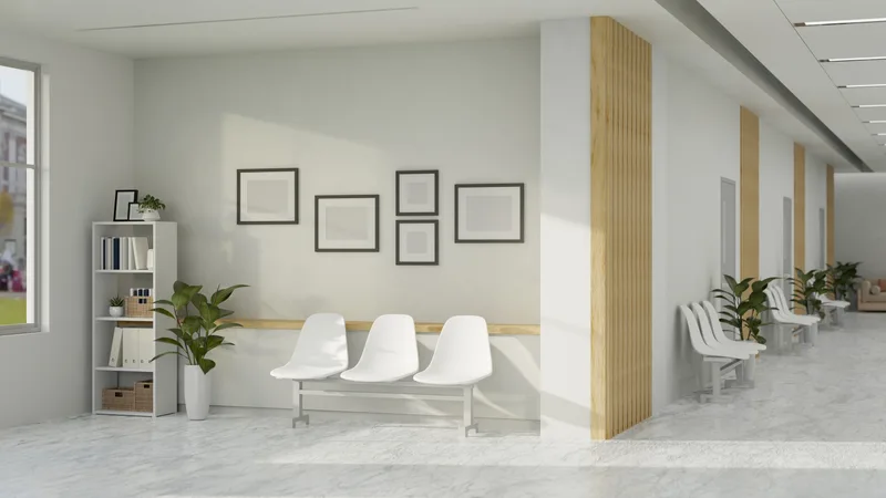 Calm, light-filled clinic waiting area with white chairs, framed pictures and potted plants