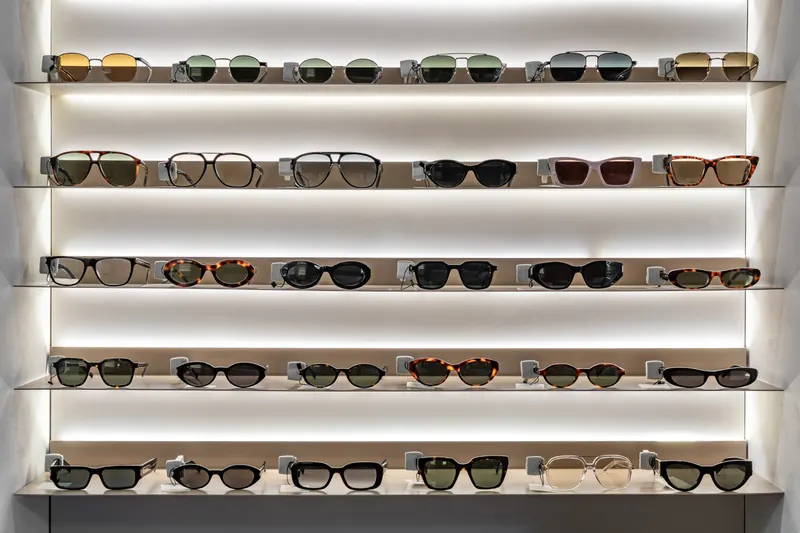 Backlit white shelves in the Sightline dispensary holding rows of acetate and metal frames