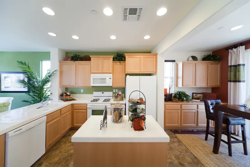 Open-plan kitchen lit by a grid of recessed ceiling pot lights