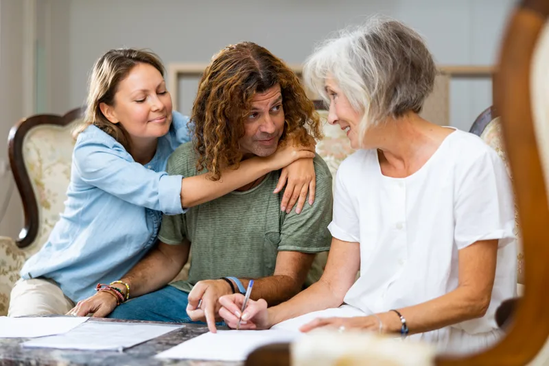 Three family members on a sofa going over plans and paperwork together