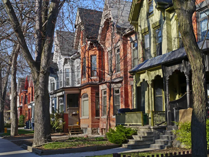 Street of restored Victorian brick houses with tall gables and bay windows