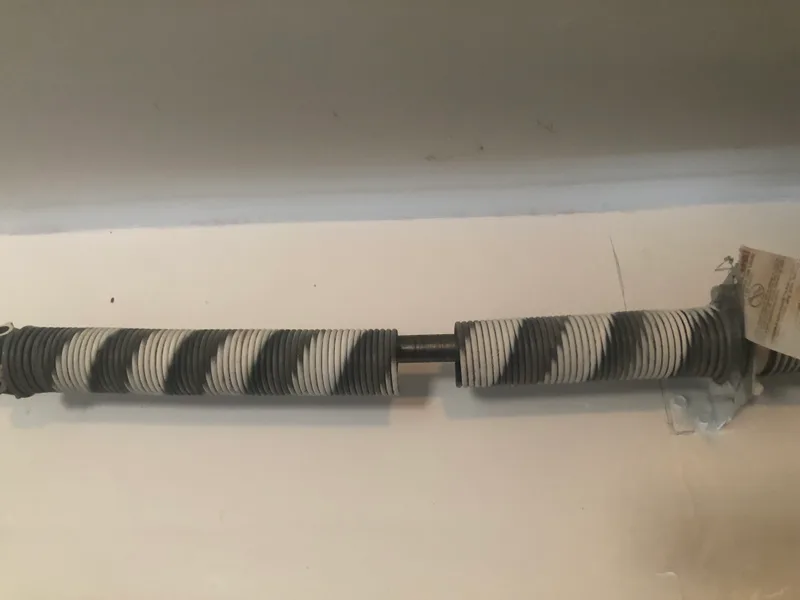 A snapped garage door torsion spring with a clear gap in the coil