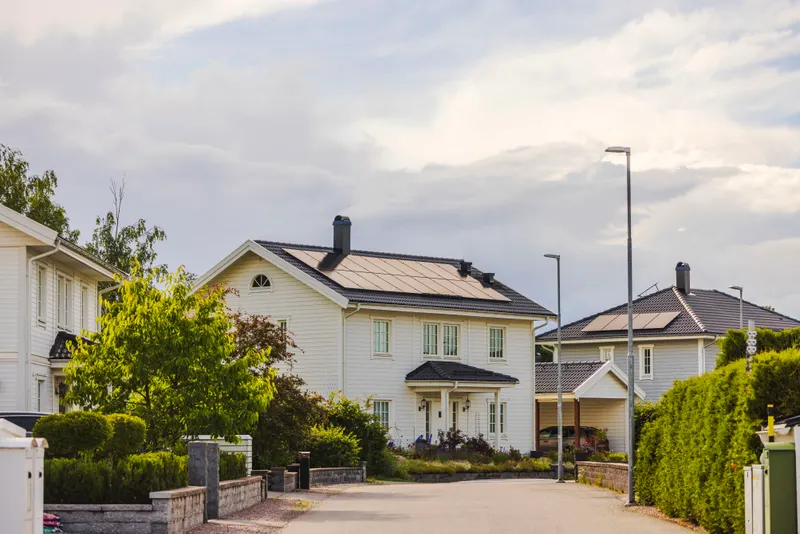 Two-story home with a full rooftop solar array on a quiet residential street