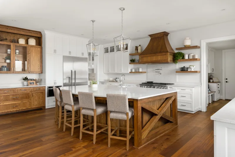 Bright kitchen with a wood island and warm oak floors running through to the dining area