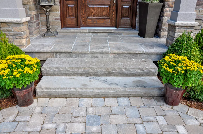 Thermal bluestone entry steps flanked by planted urns of yellow mums