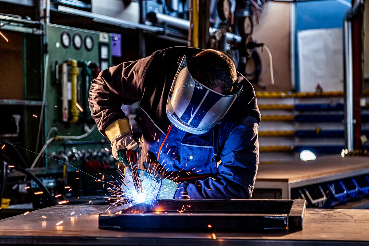 Machinist operating CNC equipment on a manufacturing shop floor