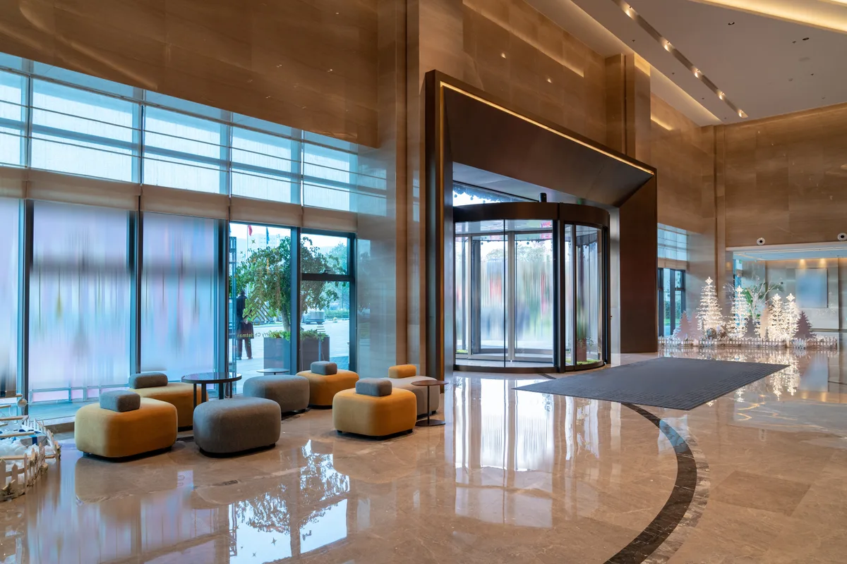 Guests checking in at a hotel front desk in a bright, modern lobby